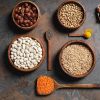 Bowls filled with beans and lentils lying on a table top.